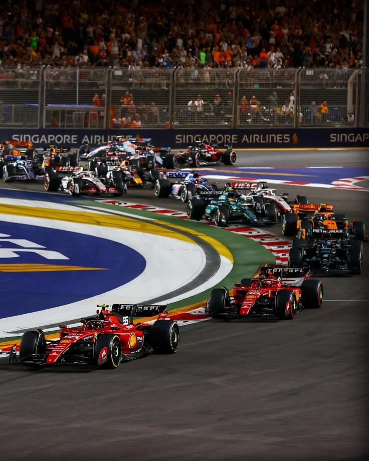 Ferrari F1 cars leading at night race Grand Prix